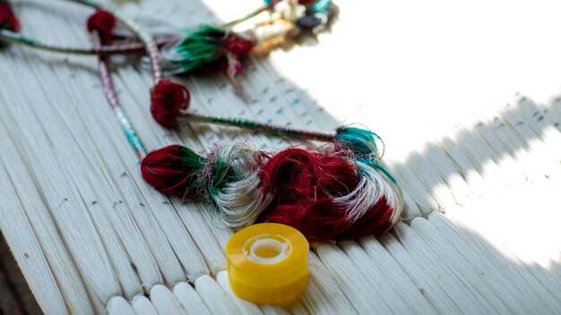 Kłębek nici i igła na tle tkaniny